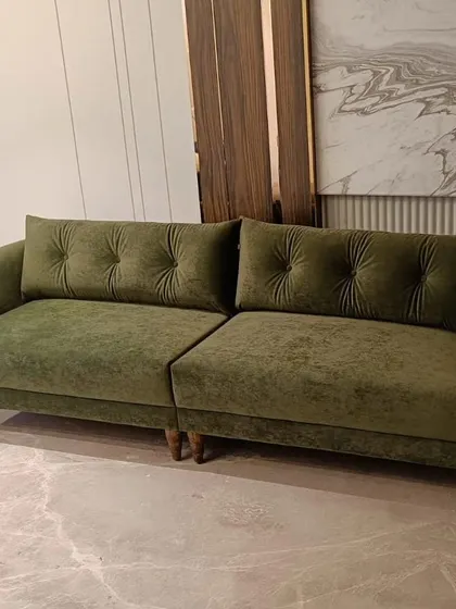 We crafted this deep green sofa with plush, tufted back cushions for a client seeking both comfort and a touch of color. The solid wood legs and rich velvet fabric make it a durable and stylish addition to any living space.