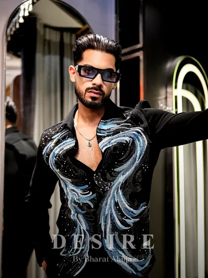 Sculpted in shimmer and styled to stun. This black shirt features abstract waves of blue and silver beadwork, creating a look of pure, refined edge for an unforgettable entrance.
