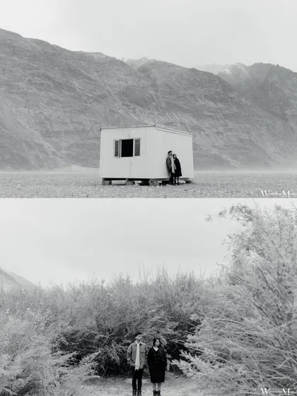 A minimalist, artistic shot in Ladakh. The simple composition of the couple against a small structure in a vast landscape creates a powerful and memorable image.
