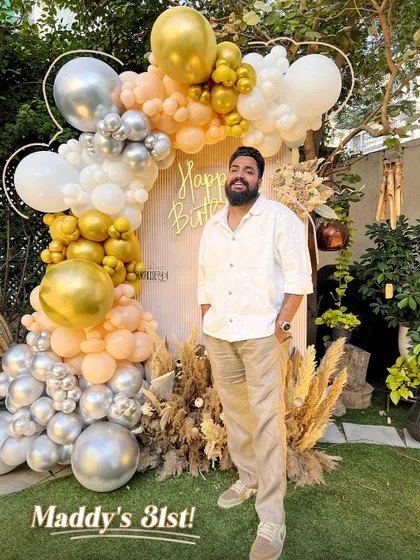 Maddy's 31st! The birthday boy enjoying his custom-designed outdoor party decor. The neutral-toned balloon arch and pampas grass details perfectly complemented the garden setting.