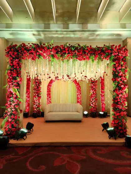 For a bold and passionate statement, we use a rich palette of red roses to create a stunning mandap and stage. The design features a canopy of flowers and hanging floral strings, enveloping the couple in traditional elegance.