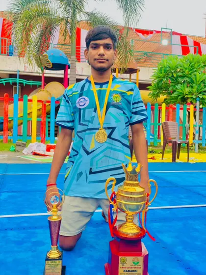 A player proudly displays his winner's trophy and gold medal from the CBSE cluster games.