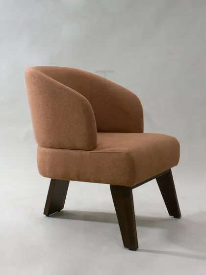 This armchair, with its curved back and angled wooden legs, embodies refined modern aesthetics. The warm, earthy fabric makes it a versatile piece for any contemporary living space.