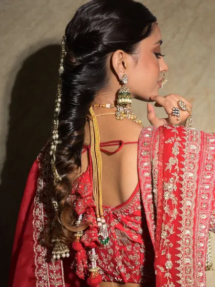 This twisted braid is adorned with a delicate pearl chain, adding a touch of elegance and sophistication. It's a beautiful choice for a classic bridal look.