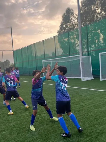 A high-five between teammates during training, a small moment that builds team spirit.