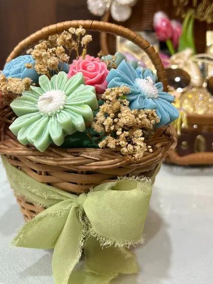A close-up of the adorable mini basket filled with colorful, handcrafted flower-shaped soaps. It's a unique and beautiful Rakhi gift.