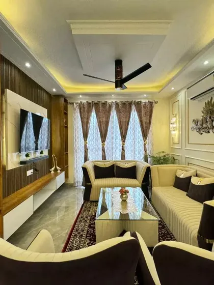 A beautifully delivered living room in Faridabad, featuring a mix of neutral sofas, a glass-top coffee table, and elegant curtains, creating a bright and airy space.