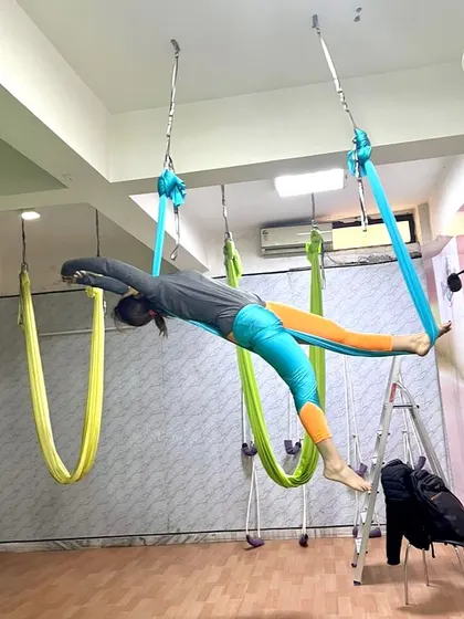 As a yoga instructor, taking my practice to the sky is a passion. This pose, a variation of the flying pigeon, is a deep hip opener that also challenges balance and core strength.