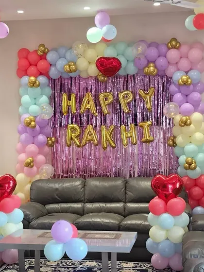 A closer view of the 'Happy Rakhi' backdrop, showing the shimmer curtain and heart-shaped foil balloons.
