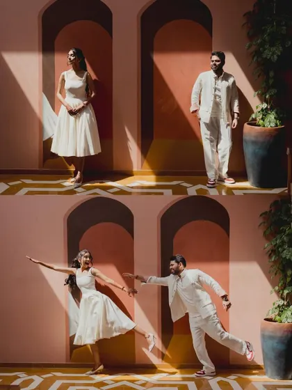 An architectural shot of a couple posing against a stunning pink and yellow wall, playing with light and shadow for a creative and modern portrait.