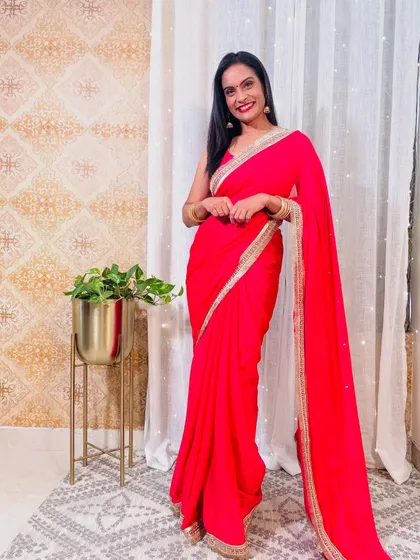 A classic red georgette saree with a simple gold border. This is a timeless piece that is perfect for any celebration, from Karva Chauth to a wedding.
