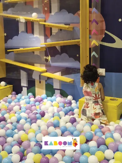 A little one captivated by our interactive ball wall, a perfect example of how we blend play with learning.