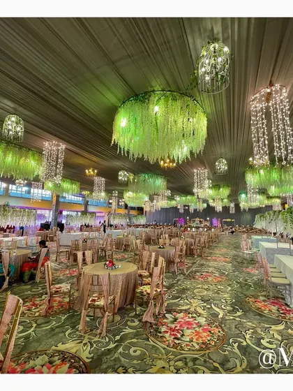 The dining area setup for 'The Bhosale Wedding'. We used custom-printed carpets and hanging floral installations with crystal chandeliers to create an enchanting garden-like atmosphere for the meal service.