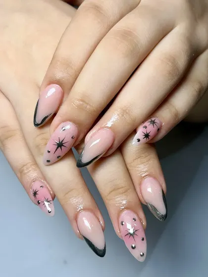 A dreamy and celestial design. This set features a sheer pink base with black French tips, black stars, and silver chrome accents for a galaxy-inspired look.