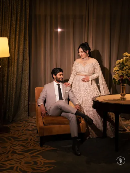 A sophisticated and elegant portrait of the couple in their hotel suite. The warm, ambient lighting creates a cozy and intimate atmosphere for this reception look.