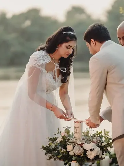 A few moments before they say "I do." The couple stands together at the altar, sharing a look of love and anticipation, with the serene lakeside and elegant floral decor creating a perfect backdrop.