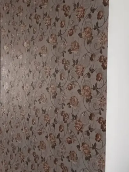 A classic rose floral wallpaper in muted tones adds a touch of vintage charm to this living space. The traditional pattern is perfect for creating a warm and comfortable atmosphere.