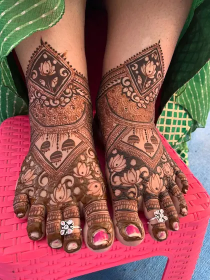 A stunning feet design with lotus and jhumka motifs. The bride's toe rings add a lovely finishing touch to the overall look.