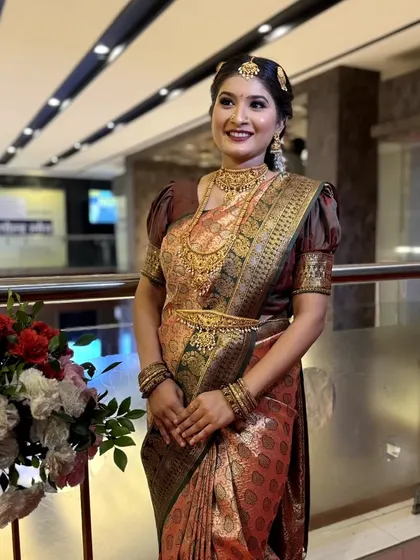 A full-length shot of the South Indian bride, allowing students to see how the makeup, hairstyle, and magnificent saree create a cohesive and regal appearance.