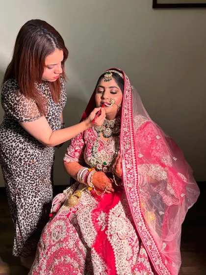 A behind-the-scenes shot of me working on the lovely bride, Dipika. Here, I am carefully applying her lipstick to create the perfect pout.