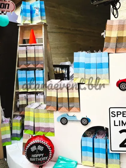 Even the party favors are part of the decor. Here, colorful gift bags are neatly displayed on a custom shelf, integrated into the overall race car theme.