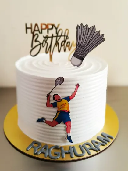 A clean and simple badminton themed cake, perfect for a player's birthday. It features a racket, shuttlecock, and a player in action.