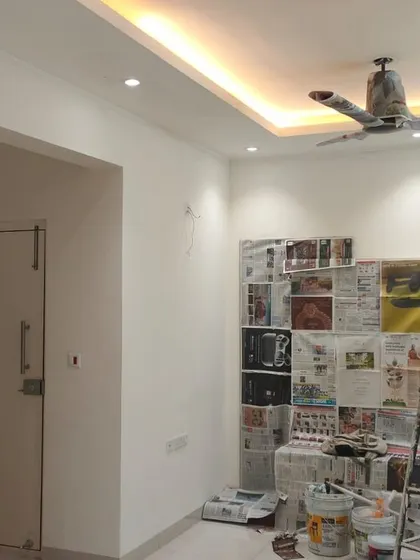 This image shows a room after the first coat of paint, with all the prep work visible. We use newspaper and sheets to protect built-in furniture and fixtures, ensuring clean lines and no mess.