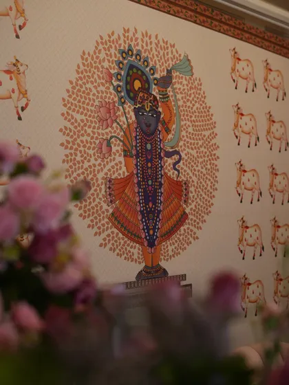 A glimpse of the custom-printed backdrop featuring a beautiful illustration of Shrinathji, adding a deeply personal and cultural element.