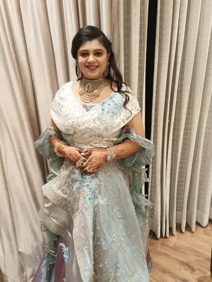 A front view of the client, her soft curls framing her face beautifully. This hairstyle is elegant and perfect for any wedding guest or bridesmaid.