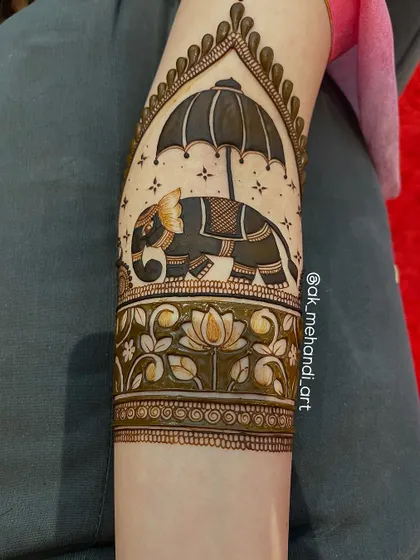 Another variation of the elephant with umbrella design, this time incorporated into a larger arm band with floral patterns.