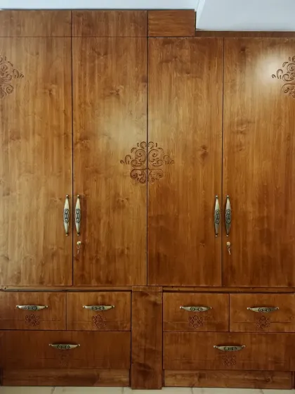 A detailed look at the custom wardrobe in the Sampada Home. The warm wood grain is enhanced by delicate carved motifs and elegant, traditional hardware, showcasing our attention to detail.