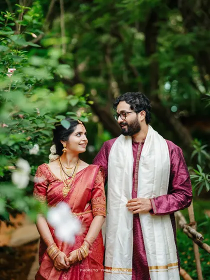 A lovely portrait of the couple in a lush garden at the Shankara Foundation, a perfect blend of nature and tradition.