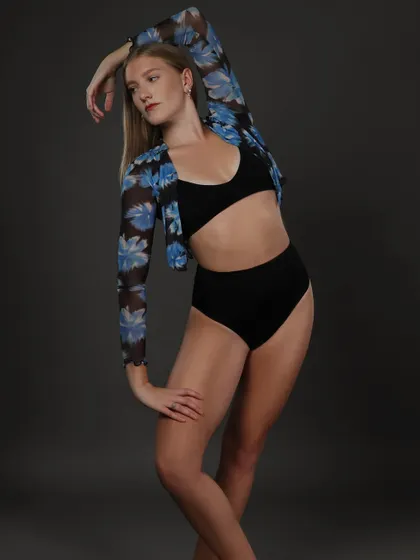 A dynamic pose that shows off the model's ability to create interesting shapes with her body. The simple styling keeps the focus on her form and movement.
