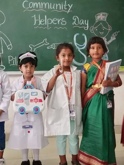 A group of girls dressed as teachers and doctors for Community Helpers Day, holding books and medical kits to represent their chosen professions.