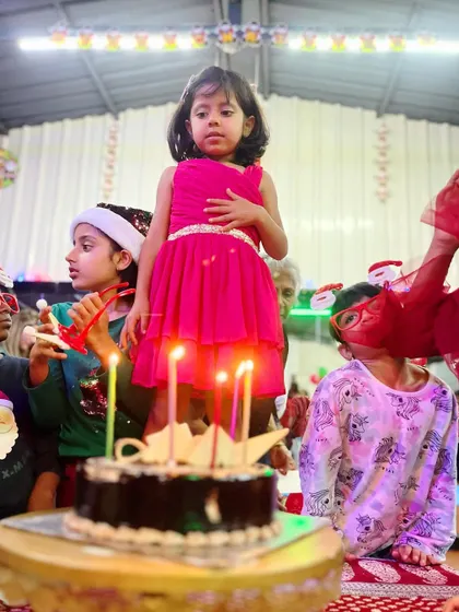 The magic of a birthday wish. Surrounded by friends and candles, this little one is the center of attention at her studio party.