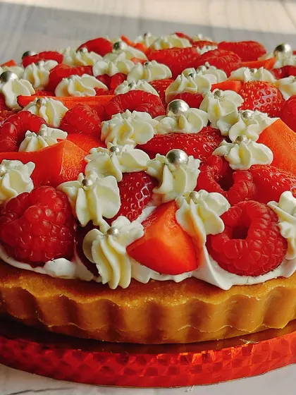A close-up of my raspberry and strawberry cheesecake tart, showing the juicy fresh berries and silver pearls that add a touch of elegance.