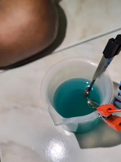 A close-up of a simple battery and electrode setup in a beaker, the core of many of our fun chemistry experiments.