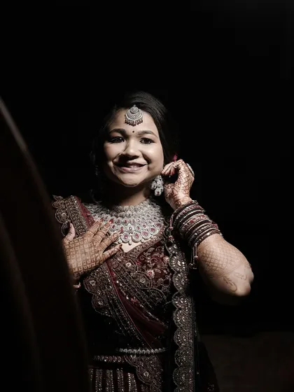 A happy, smiling portrait of the bride looking through an archway, capturing a moment of pure joy.