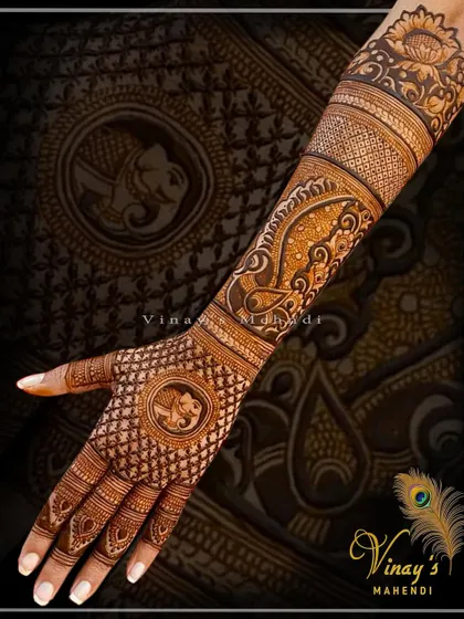 A traditional back-hand design with elephant and peacock motifs. The dense jaal work on the hand is a classic bridal element.