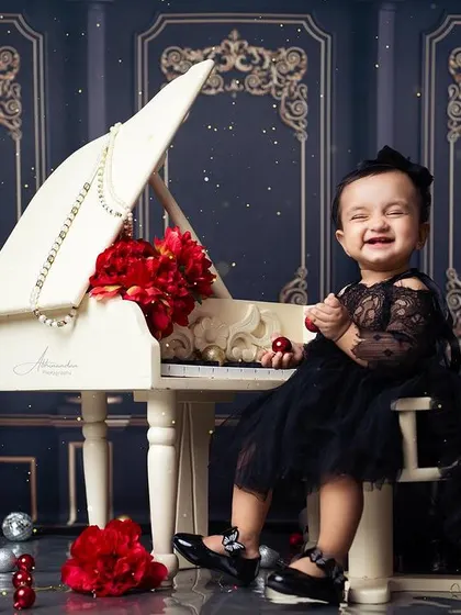 A classic and elegant first birthday portrait, with our white piano and a gorgeous black dress.