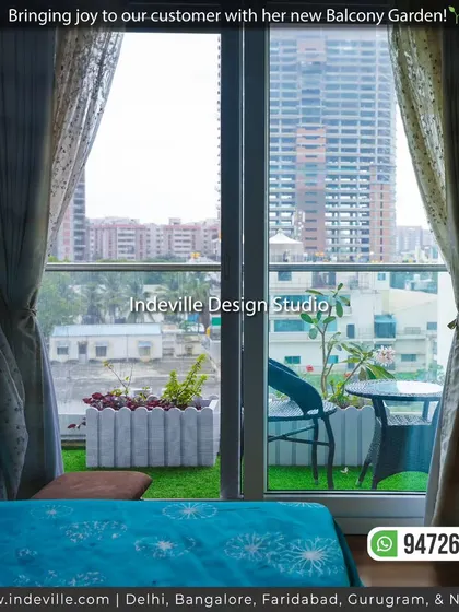The view from inside, looking out onto the client's new balcony garden. The artificial grass and white planters create a refreshing green view against the urban backdrop.