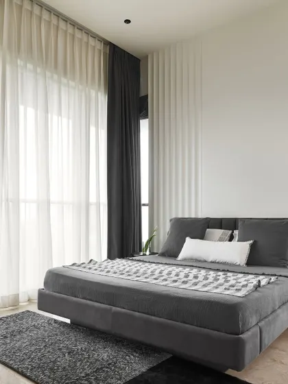 The Slate Bedroom features a dark grey palette for a sophisticated, calming mood. A floating bed frame and soft, layered textiles enhance the feeling of a tranquil retreat designed for ultimate relaxation.