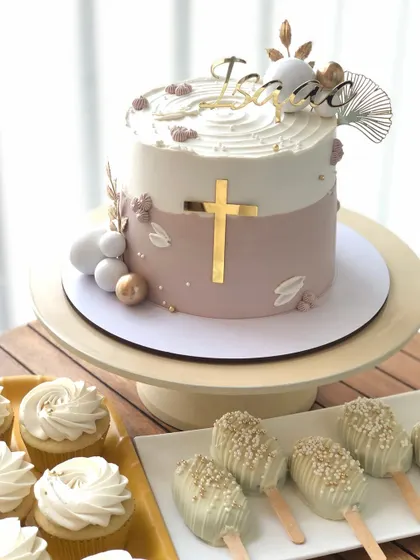 A beautiful and elegant baptism cake for baby Isaac, paired with matching white and gold cupcakes and cakesicles.