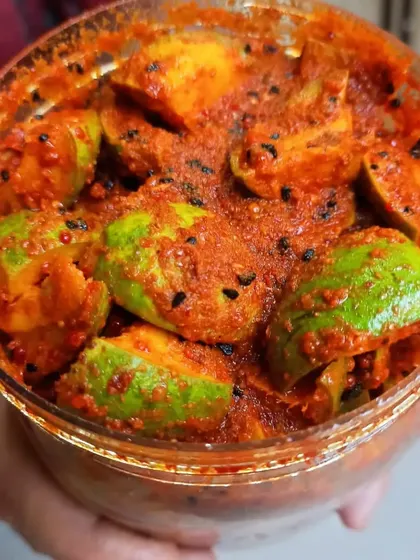 Holding up a jar full of freshly made Mango Pickle. This view shows the density and richness of the pickle before the jar is sealed.