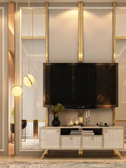A sleek and modern TV unit design featuring a mirrored back panel with gold-toned metal strips. The floating console and minimalist decor create a clean, uncluttered look that is perfect for contemporary homes.