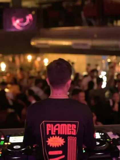 A shot from behind showing my 'Flames' t-shirt, looking out at the packed club. I'm here to bring the heat to the dance floor.