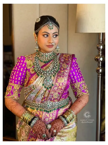 A full portrait of Nidhi's stunning purple saree look. The makeup, jewelry, and styling all come together to create a look of unparalleled bridal grandeur.