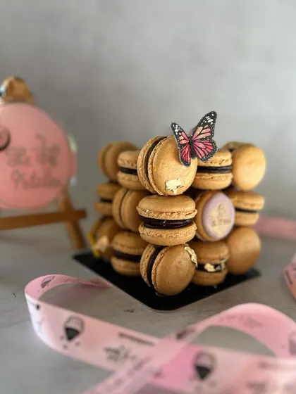 A close-up of the stacked macarons, showing the gold leaf detail and the custom-stamped macaron with my logo.