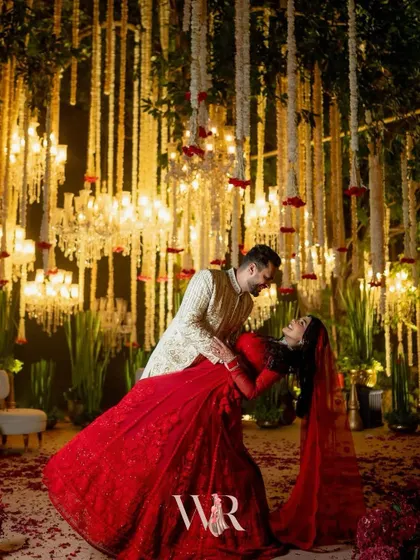 A cinematic moment captured under a sky of cascading mogra and crystal chandeliers. We designed this backdrop for a timeless varmala ceremony, where the bride's radiant red lehenga stood out against the soft ivory, creating a memory as eternal as their love story.
