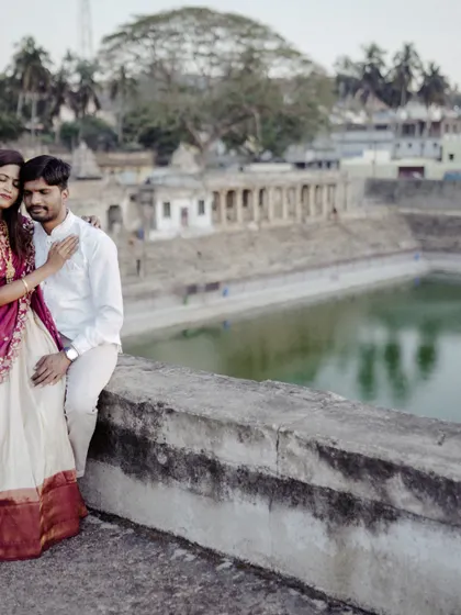 Posing by the serene temple tank, this couple's traditional outfits look stunning against the historic backdrop. A perfect blend of culture and romance.